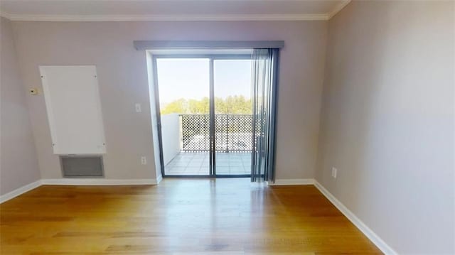 spare room featuring crown molding and light hardwood / wood-style flooring