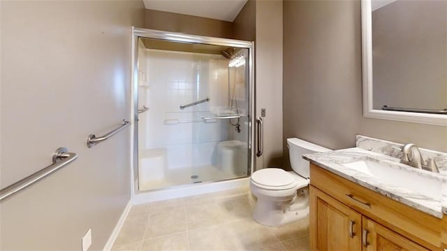 bathroom featuring tile patterned flooring, vanity, toilet, and a shower with door