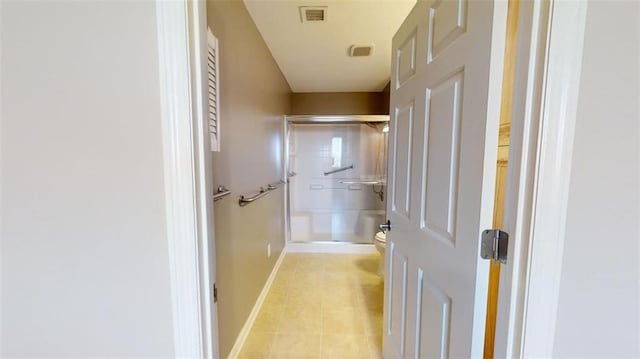 bathroom with tile patterned floors, toilet, and an enclosed shower