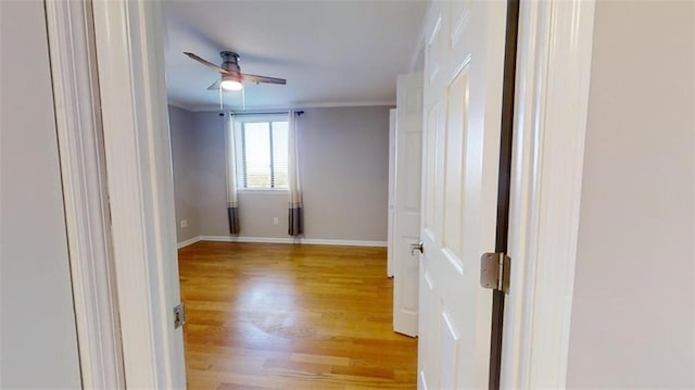 spare room with ceiling fan, light wood-type flooring, and ornamental molding