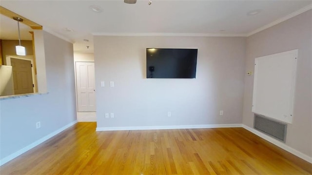 unfurnished living room featuring crown molding and hardwood / wood-style flooring