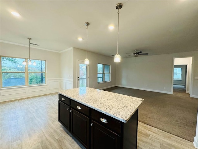 kitchen featuring ceiling fan, light hardwood / wood-style floors, decorative light fixtures, and ornamental molding