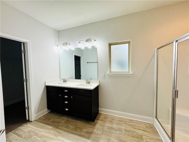 bathroom with hardwood / wood-style floors, vanity, and an enclosed shower