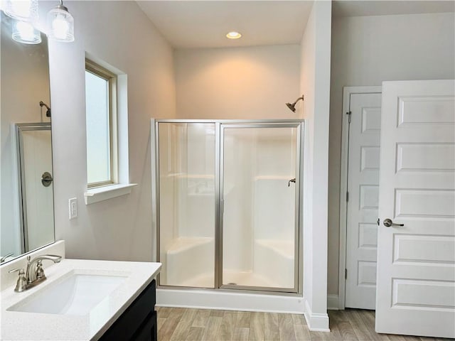 bathroom with vanity, an enclosed shower, and hardwood / wood-style flooring