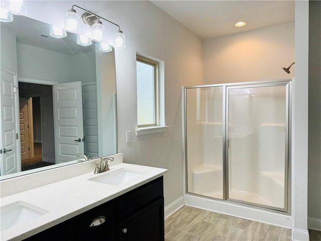 bathroom with hardwood / wood-style flooring, vanity, and walk in shower