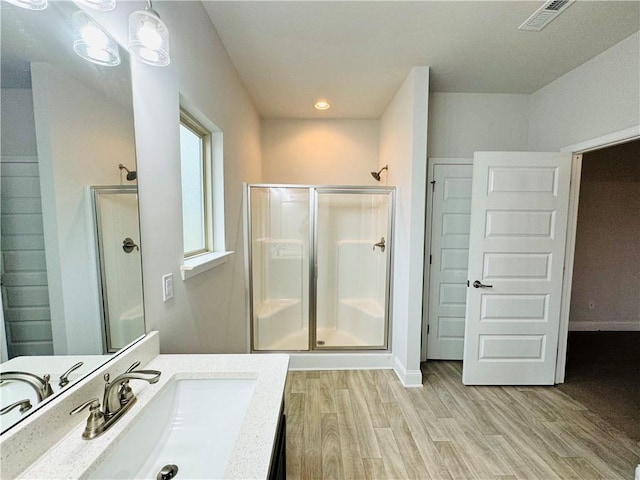 bathroom with vanity, hardwood / wood-style flooring, and a shower with shower door