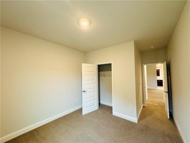 unfurnished bedroom featuring light carpet and a closet