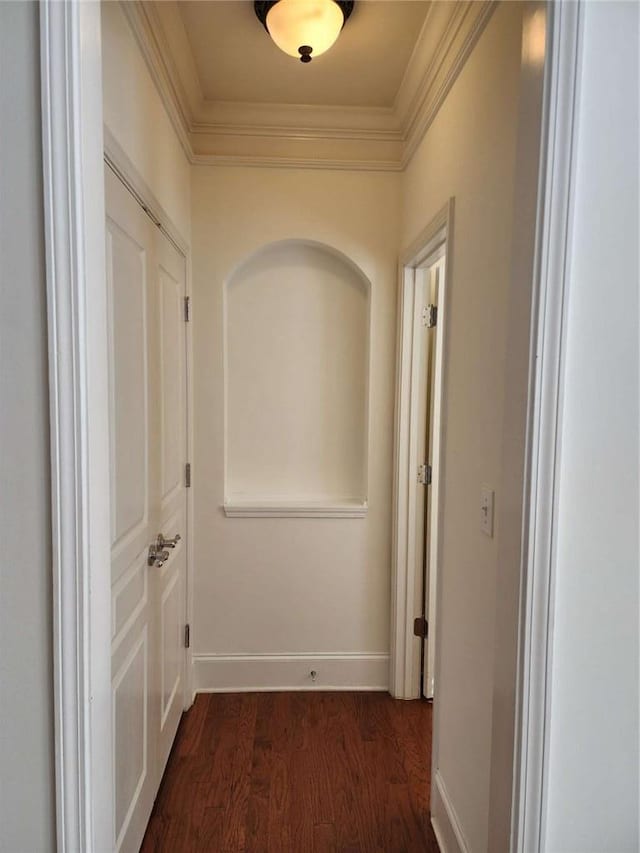 hall with baseboards, ornamental molding, and dark wood finished floors