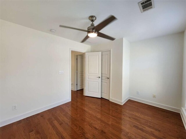 unfurnished bedroom with a ceiling fan, wood finished floors, visible vents, and baseboards