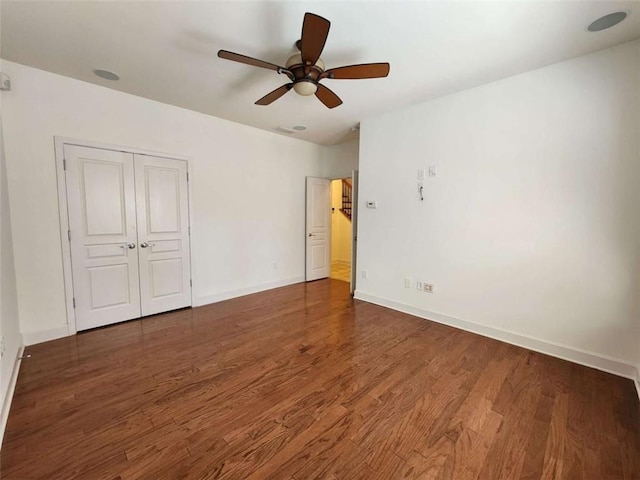 unfurnished bedroom with a closet, baseboards, and wood finished floors