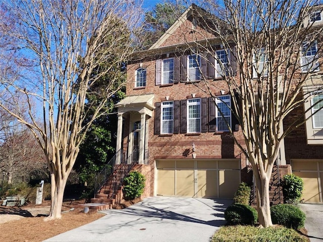 view of front of home featuring a garage, concrete driveway, and brick siding