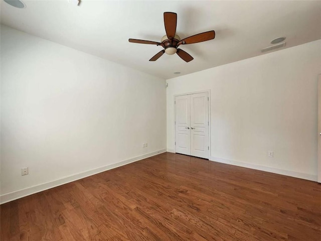 spare room featuring visible vents, ceiling fan, baseboards, and wood finished floors