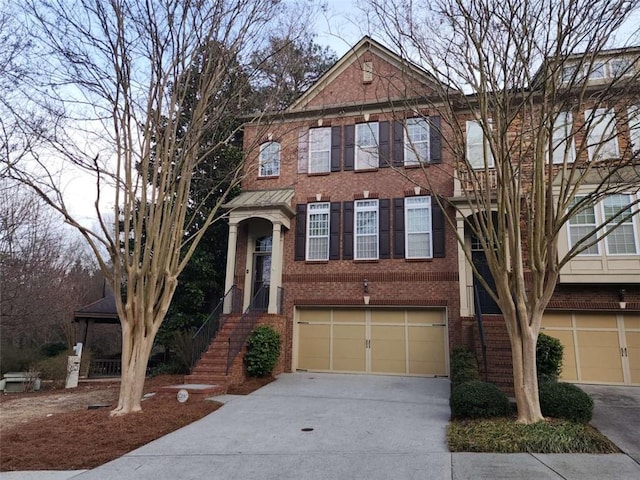 view of property with an attached garage, concrete driveway, and brick siding