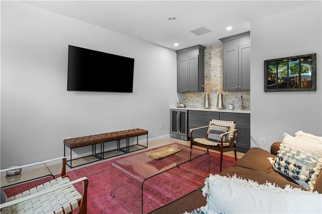 living room featuring wine cooler, recessed lighting, visible vents, baseboards, and wet bar