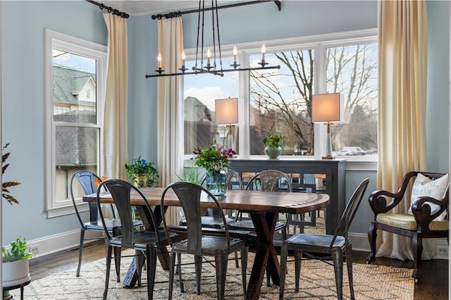 dining area with a notable chandelier, baseboards, and wood finished floors