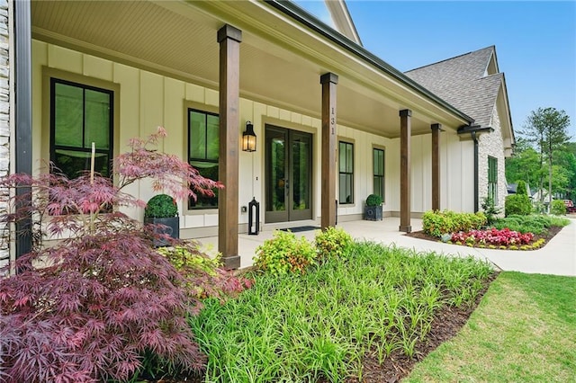 131 Forsyth Park Ln, Woodstock, GA 30188 - view of exterior entry with board and batten siding, french doors, a shingled roof, and a porch