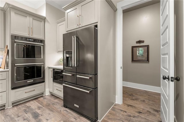 131 Forsyth Park Ln, Woodstock, GA 30188 - kitchen with high end fridge, double wall oven, wood finished floors, and baseboards