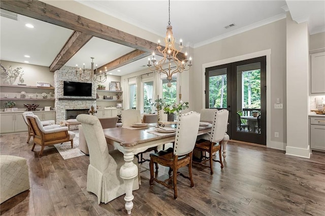 131 Forsyth Park Ln, Woodstock, GA 30188 - dining room featuring french doors, a chandelier, dark wood-style floors, a stone fireplace, and crown molding