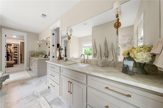 131 Forsyth Park Ln, Woodstock, GA 30188 - full bathroom with vanity, marble look tiles, and a walk in closet