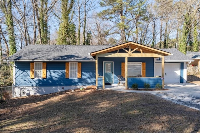 view of front of home with a porch, a garage, fence, concrete driveway, and roof with shingles