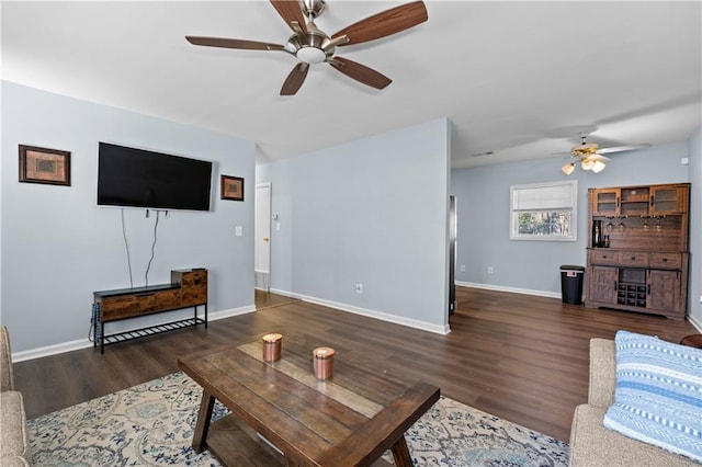 living area featuring a ceiling fan, baseboards, and wood finished floors