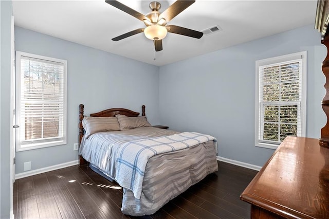 bedroom featuring dark wood-style flooring, multiple windows, and visible vents