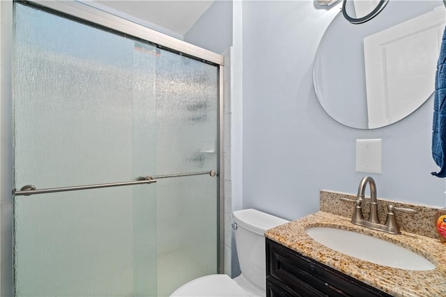 bathroom featuring a stall shower, vanity, and toilet