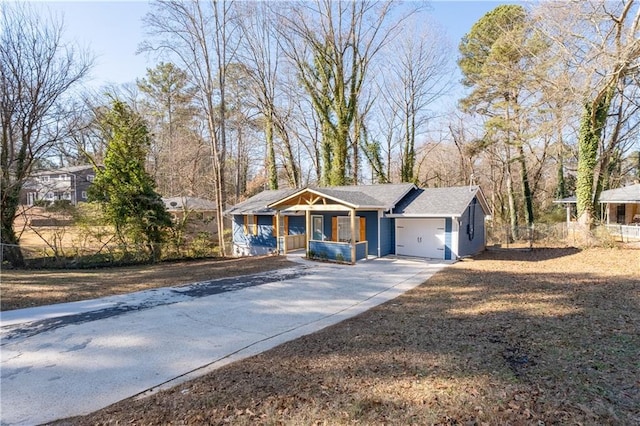 ranch-style home featuring a porch, concrete driveway, and an attached garage