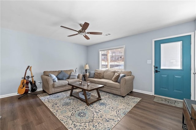 living room featuring dark wood-style floors, baseboards, visible vents, and ceiling fan