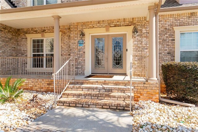 entrance to property featuring french doors and brick siding