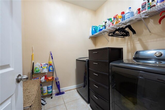 laundry area featuring laundry area, light tile patterned floors, baseboards, and separate washer and dryer