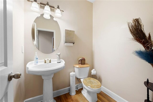 bathroom featuring wood finished floors, toilet, and baseboards