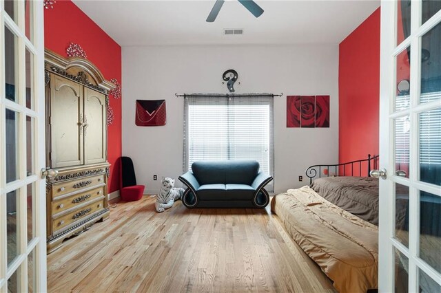 bedroom featuring ceiling fan, french doors, wood finished floors, and visible vents