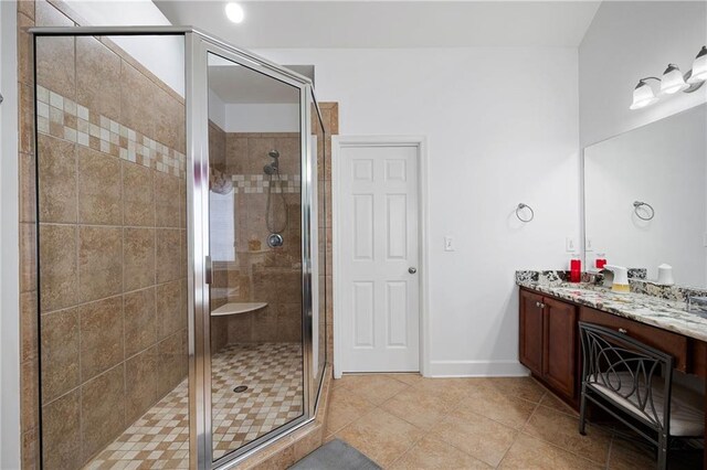 full bath featuring tile patterned flooring, a shower stall, vanity, and baseboards