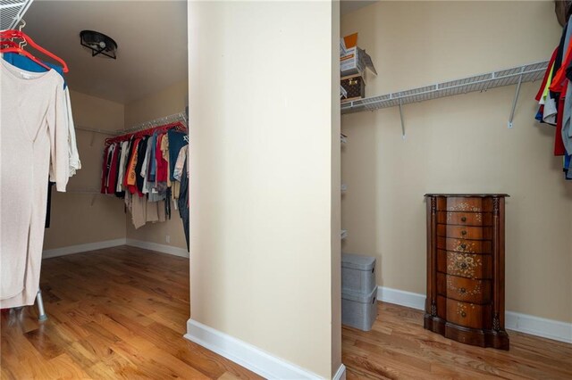 walk in closet with light wood-style flooring