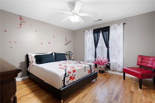 bedroom with baseboards, visible vents, ceiling fan, and light wood finished floors