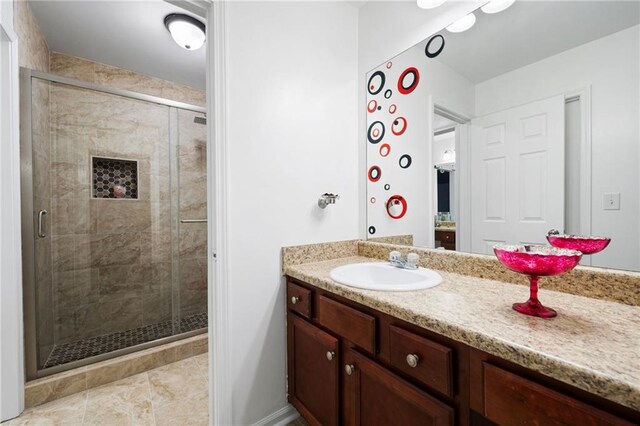 bathroom with a shower stall and vanity