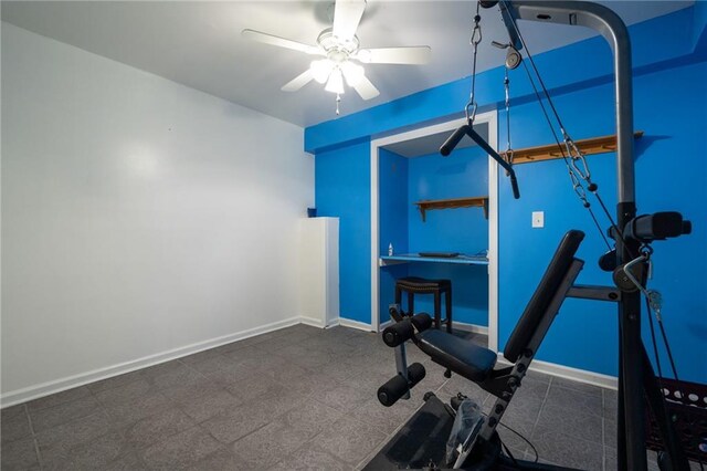 workout room with a ceiling fan and baseboards