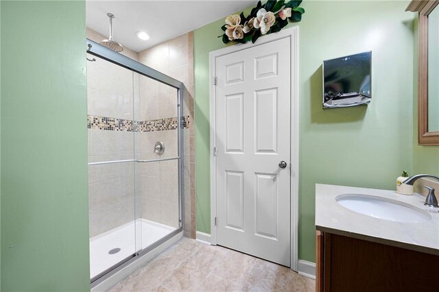 bathroom featuring a stall shower, vanity, and baseboards