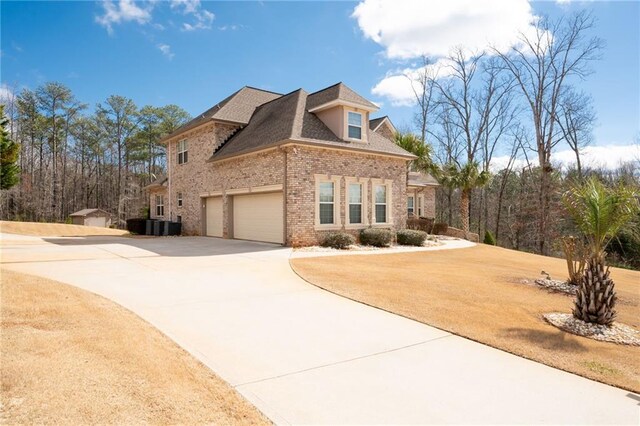 view of front of property with concrete driveway, brick siding, and a shingled roof