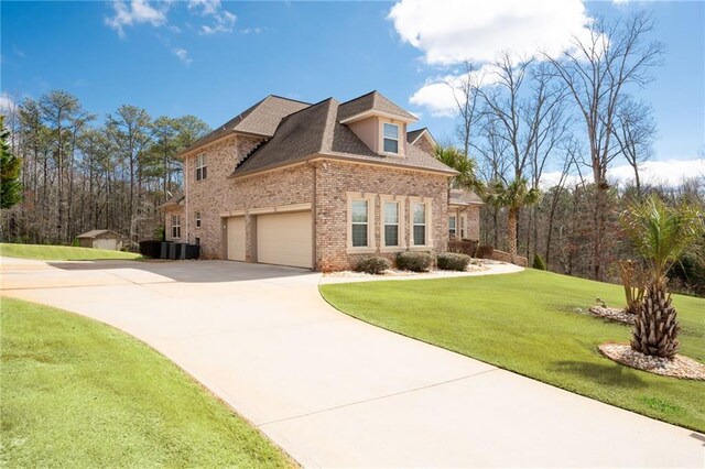 view of front of property featuring brick siding, roof with shingles, concrete driveway, and a front yard