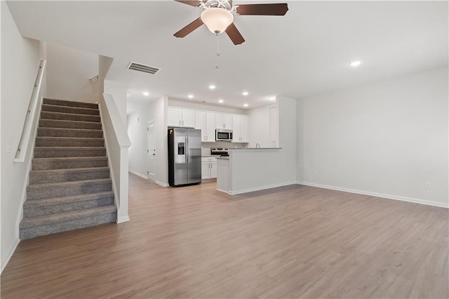 unfurnished living room with ceiling fan and light wood-type flooring