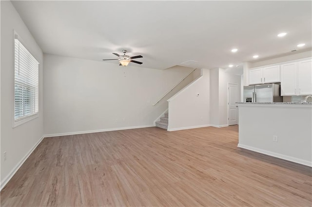 unfurnished living room with light wood-type flooring and ceiling fan