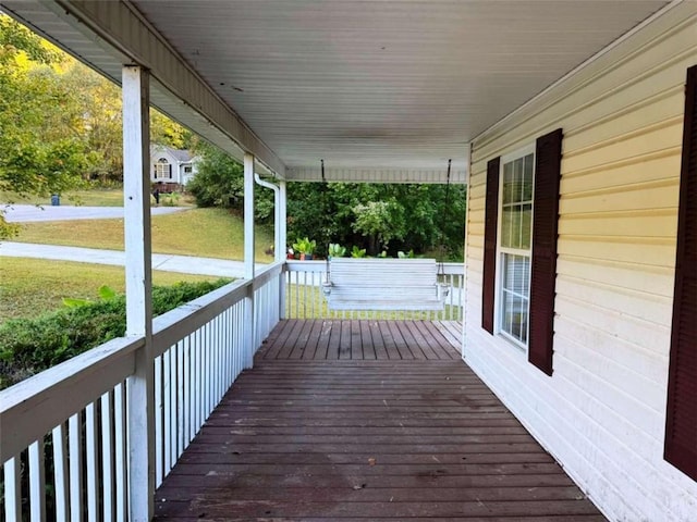 wooden deck with a porch and a lawn