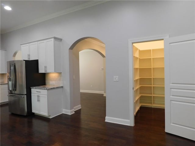 330 La Perla Dr, Sugar Hill, GA 30518 - kitchen featuring freestanding refrigerator, dark wood-style flooring, arched walkways, white cabinets, and tasteful backsplash