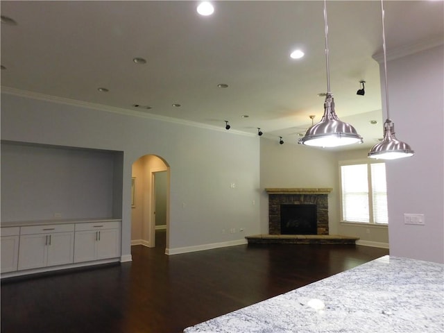330 La Perla Dr, Sugar Hill, GA 30518 - unfurnished living room featuring dark wood-style floors, arched walkways, crown molding, a stone fireplace, and recessed lighting