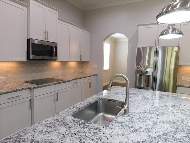 330 La Perla Dr, Sugar Hill, GA 30518 - kitchen featuring appliances with stainless steel finishes, arched walkways, backsplash, white cabinets, and ornamental molding