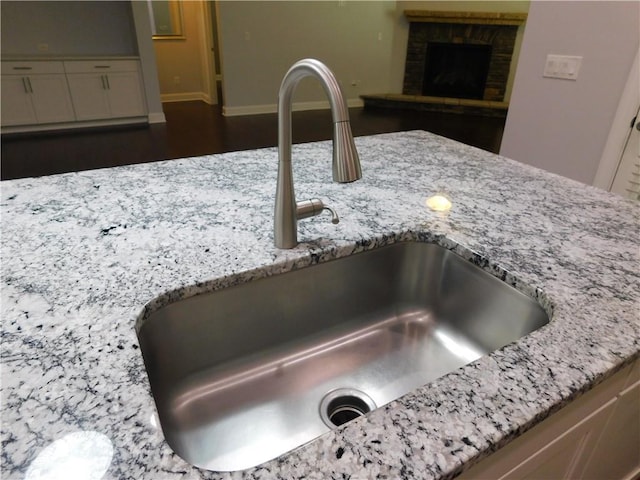 330 La Perla Dr, Sugar Hill, GA 30518 - kitchen view of light stone counters and a fireplace with raised hearth