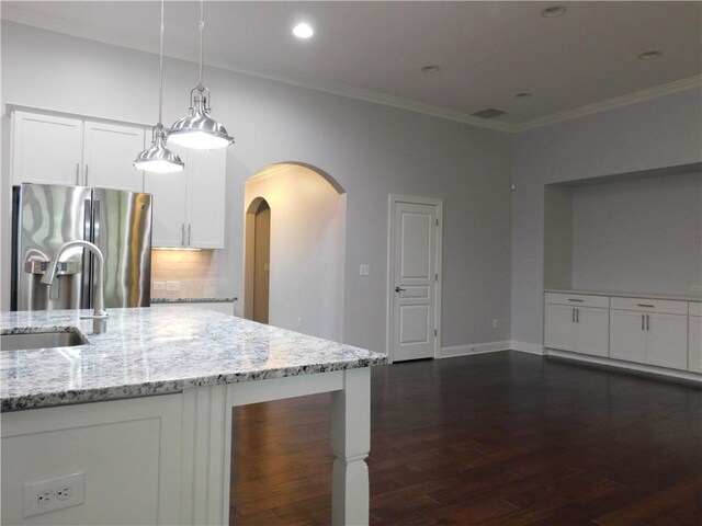 330 La Perla Dr, Sugar Hill, GA 30518 - kitchen featuring stainless steel fridge with ice dispenser, arched walkways, dark wood-style floors, backsplash, and light stone counters