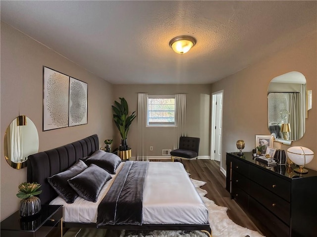 bedroom with dark wood-type flooring and a textured ceiling